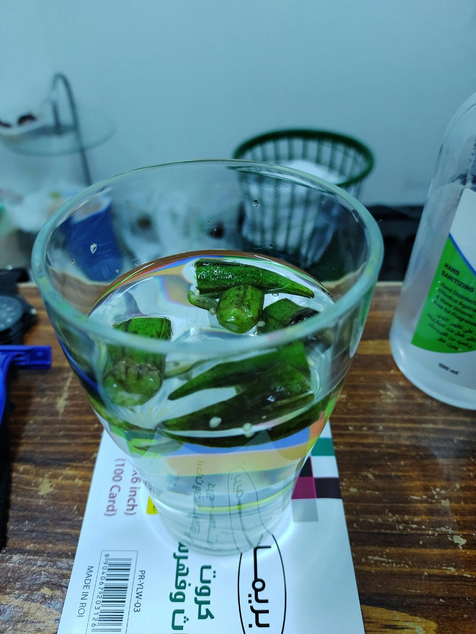 a glass filled with water and green peppers