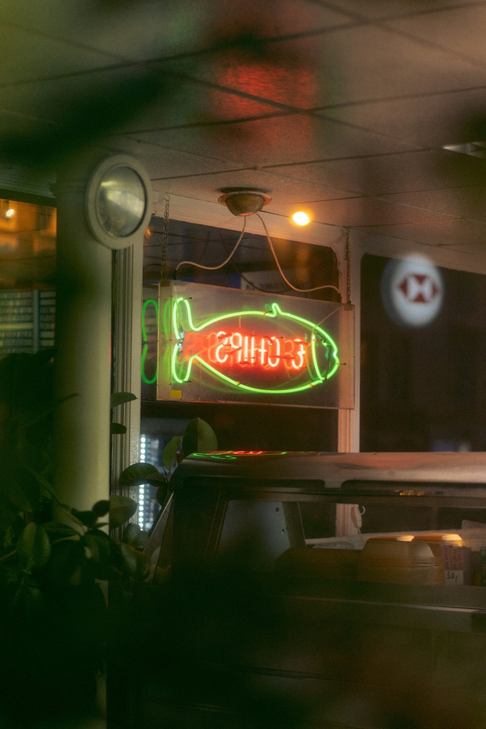 a neon fish sign on the back of a truck