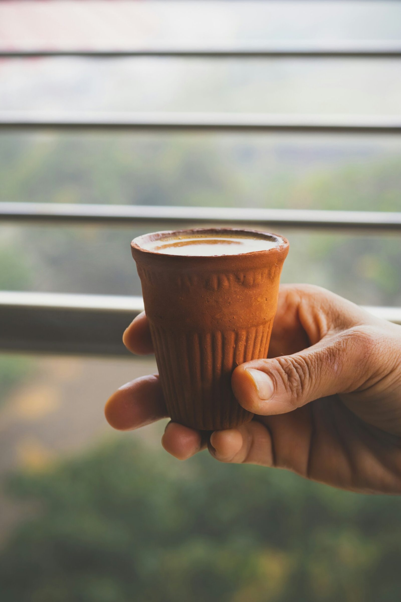 a person holding a cup of coffee in their hand